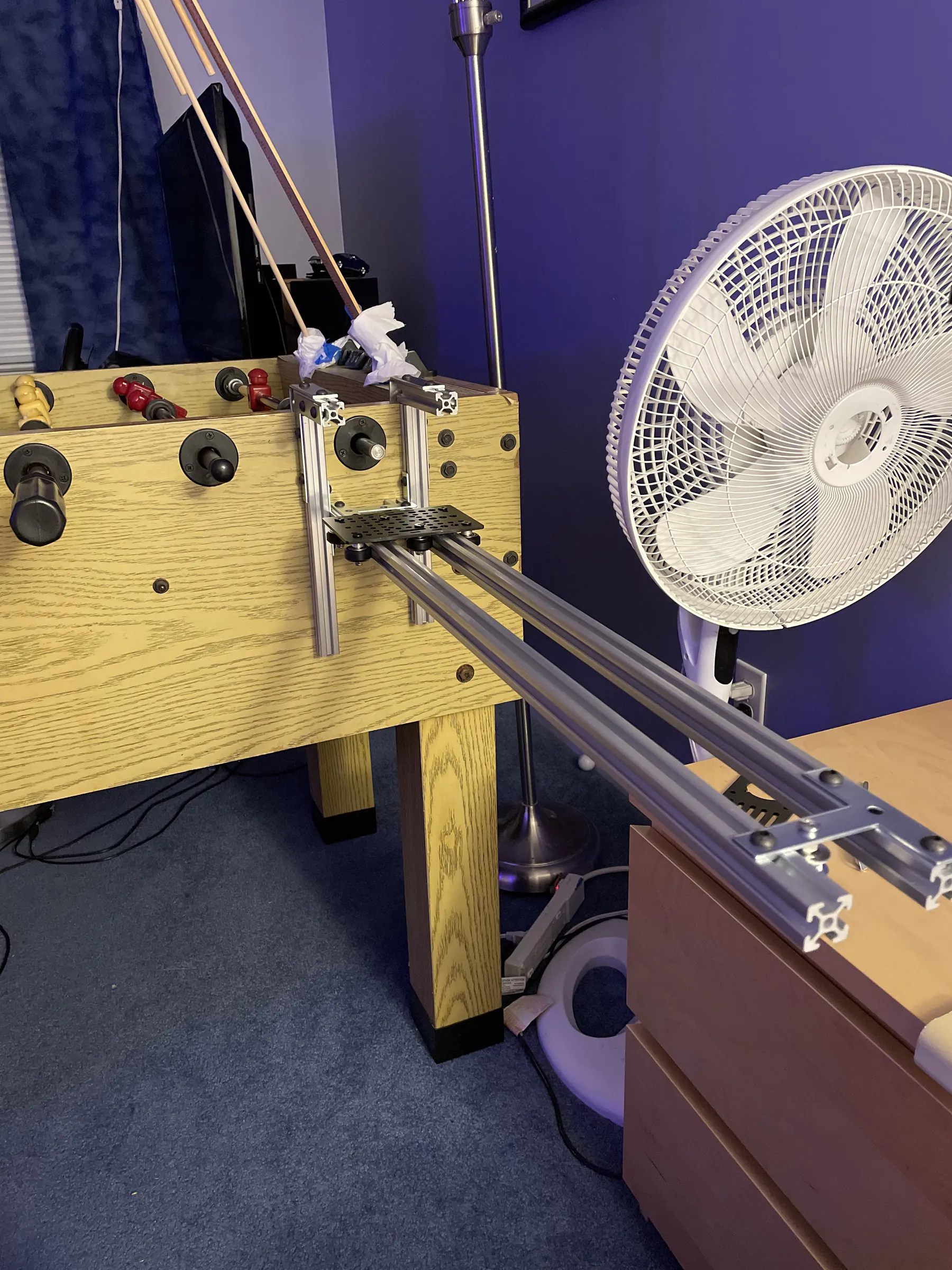 The aluminium extrusion rails mounted to the side of the table, carrying the plate that rides along them