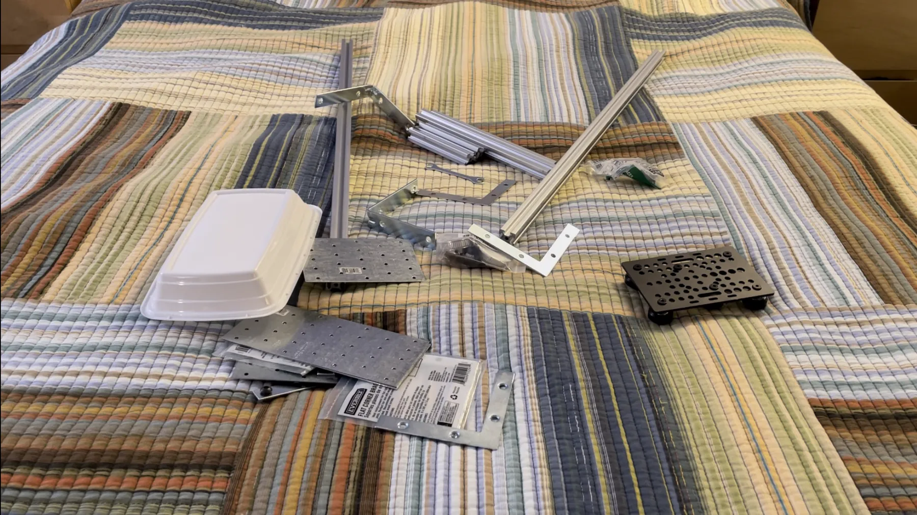 The ordered parts laid out before assembly: aluminium extrusion rails, brackets, mounting plates and hardware